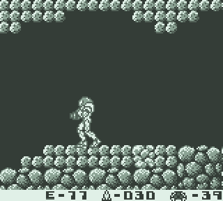 An animated GIF of Metroid II showing Samus reaching and then moving around the first Metroid egg that is normally scripted to hatch when she gets close to it. Here, it does not, and the animation ends on a still of Samus facing the screen.